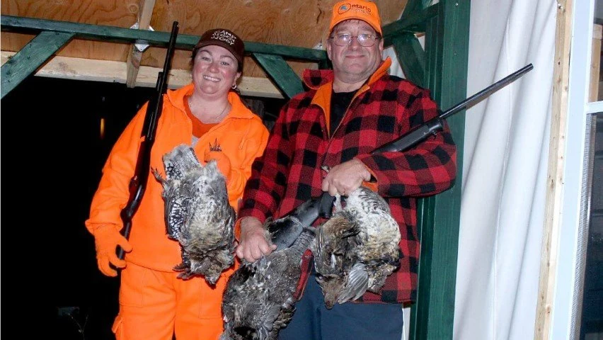 TJ and Monique holding grouse after a hunt